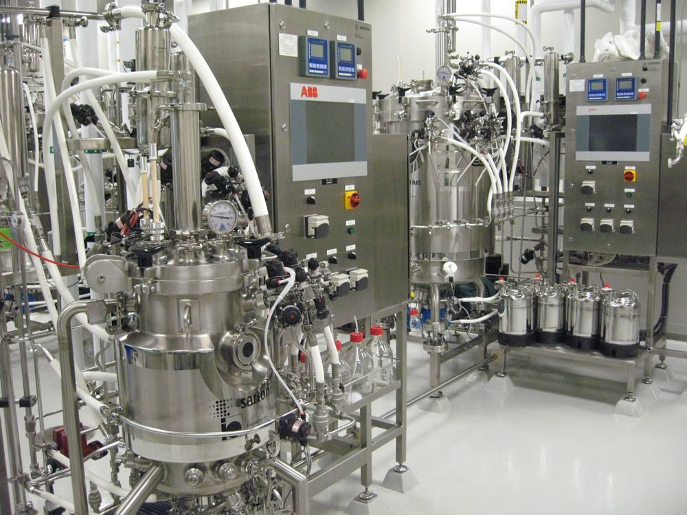 Twee roestvrijstalen bioreactoren met bedieningspanelen en leidingwerk