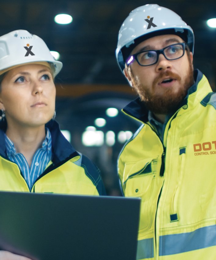 Twee DotX-engineers met helm op locatie in een fabriekshal