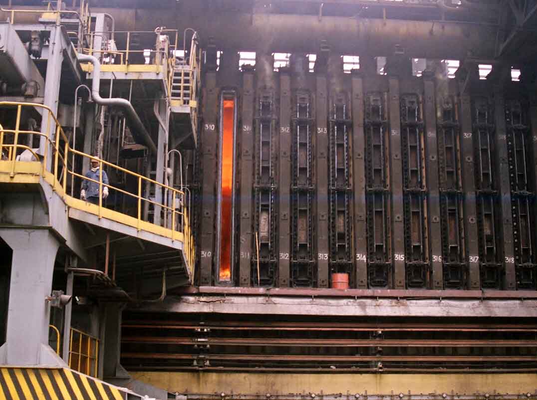 Kooksbatterij in een staalfabriek, met een operator op het bordes langs de ovenkamers