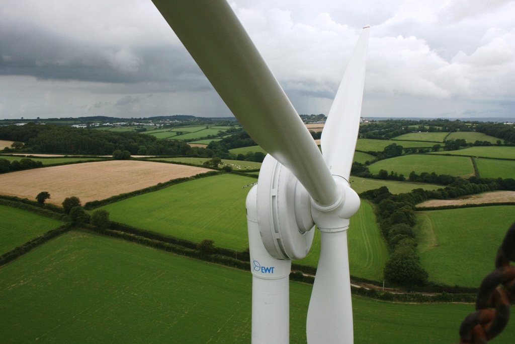 Zicht vanaf de nacelle van een EWT-turbine over de akkers, met een rotorblad op de voorgrond